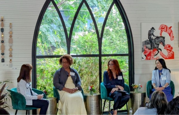 Four professional women participate in a panel discussion.