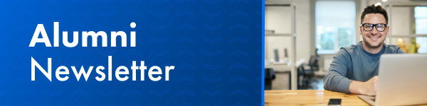 Alumni Newsletter banner with a man smiling while working on a laptop.