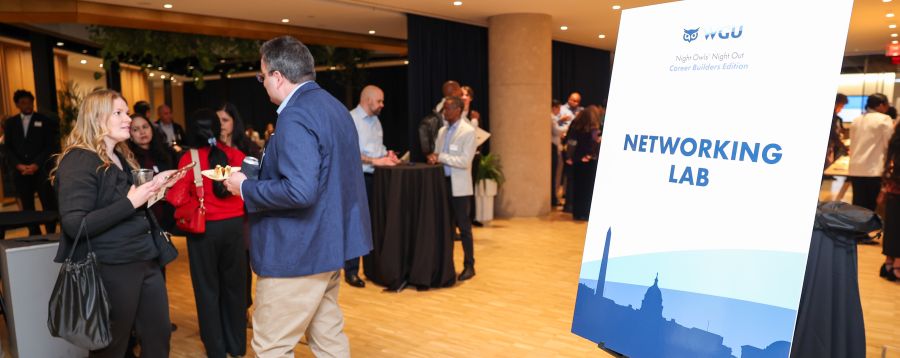 Attendees mingling and networking at an event, with a prominent sign for 'Networking Lab' visible.
