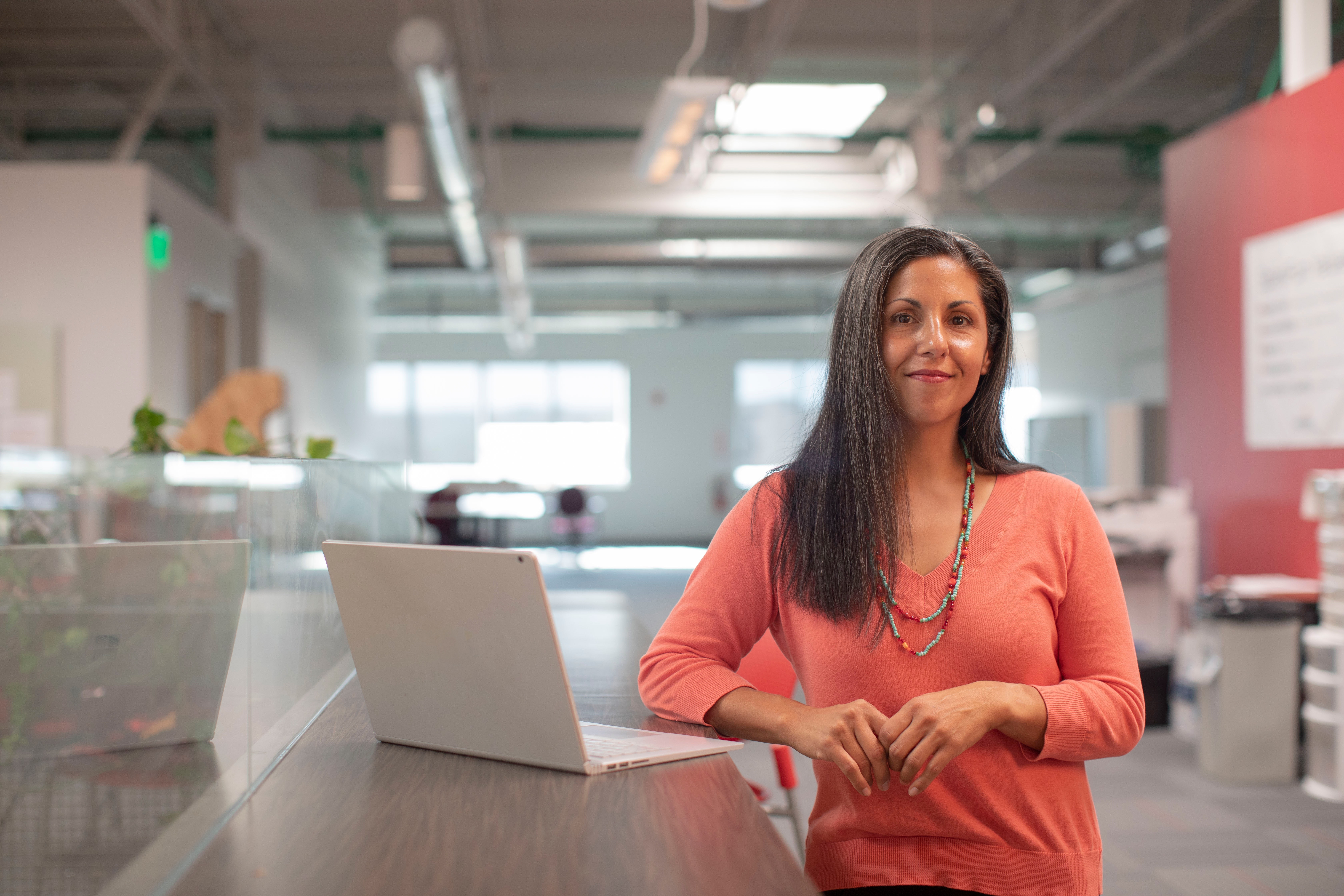 woman standing by laptop in business setting