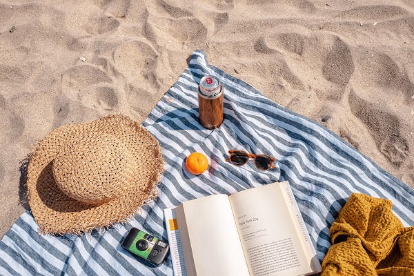 Beach towel, book, hat, sunglasses