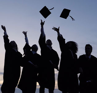 silhouette of graduates throwing their caps - apply now