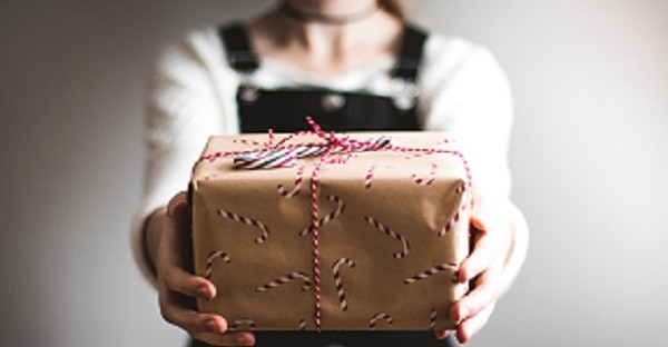 Person giving present - WGU gives gifts to their grads