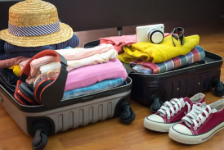 An open suitcase filled with folded clothes and accessories