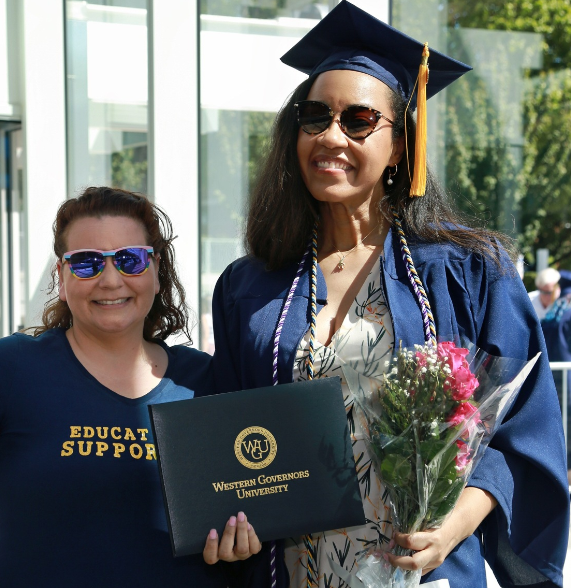 alumni grad standing next to her mentor